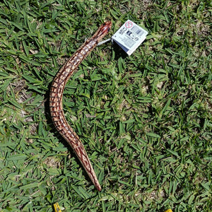 Brown snake toy on grass
