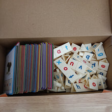 Box containing educational cards with pictures and wooden letters with letters printed on them.