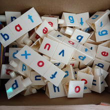Assorted letter tiles with colored letters on a cardboard surface CVC toolbox