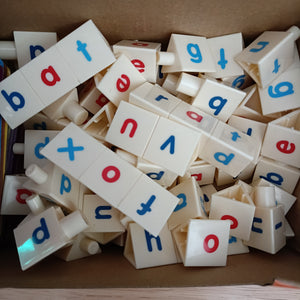 Assorted letter tiles with colored letters on a cardboard surface CVC toolbox