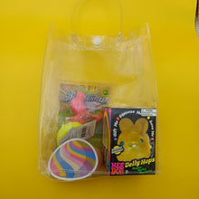 Clear plastic bag with Easter-themed items including a yellow jelly hopper and colorful packaging on a yellow background.