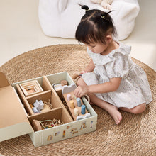 Child playing with wooden toys in a box on a woven mat