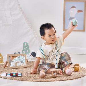 Child playing with a toy in a room with toys and a picture frame on the floor. montessori preschool babies toys