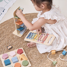 Child playing with wooden toys on a textured rug