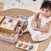 Child playing with wooden toys on a woven mat learning toys