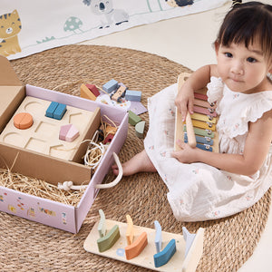 Child playing with wooden toys on a woven mat learning toys