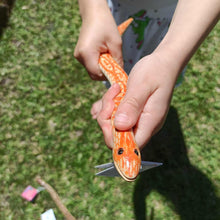 Orange toy slithering wood snake
