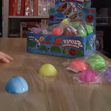 Colorful super popper toys on a table with packaging in the background Pop ball