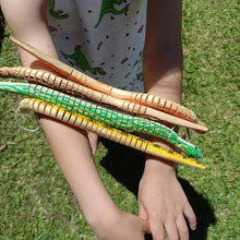 4 wooden toy snakes held by a girl