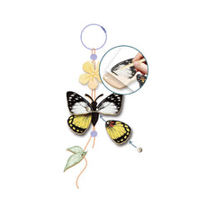Butterfly-themed decorative hanging with flowers on a white background