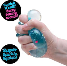 Hand holding a blue squishy toy with text about scents and sparkles.