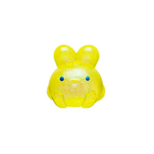 Yellow toy figure of a character with blue eyes on a white background