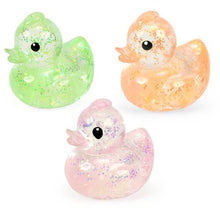 Three glittery rubber duckies in green, pink, and orange on a white background