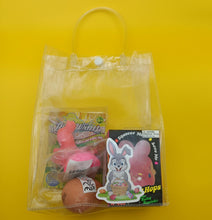Clear plastic bag with Easter-themed toys and a pink egg on a yellow background