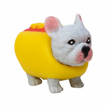 Toy figure of a dog in a yellow outfit with red accents on a white background