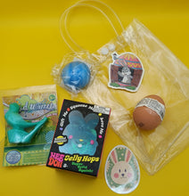 Collection of novelty items including a blue ball, egg with bandage, and packaging on a yellow background