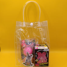 Clear plastic bag with toys and a box on a yellow background