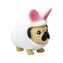 Small figurine of a dog wearing a white outfit with pink bunny ears on a white background