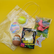 Assorted Easter-themed items including a jelly hopper, a bag, and a sticker on a yellow background