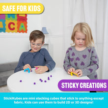 Two children playing with Sticky Creations at a table, with educational letters on the wall in the background.