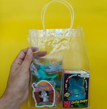 Clear plastic bag with toys and a sticker on a yellow background