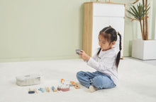 Child playing with toys on a light-colored floor.